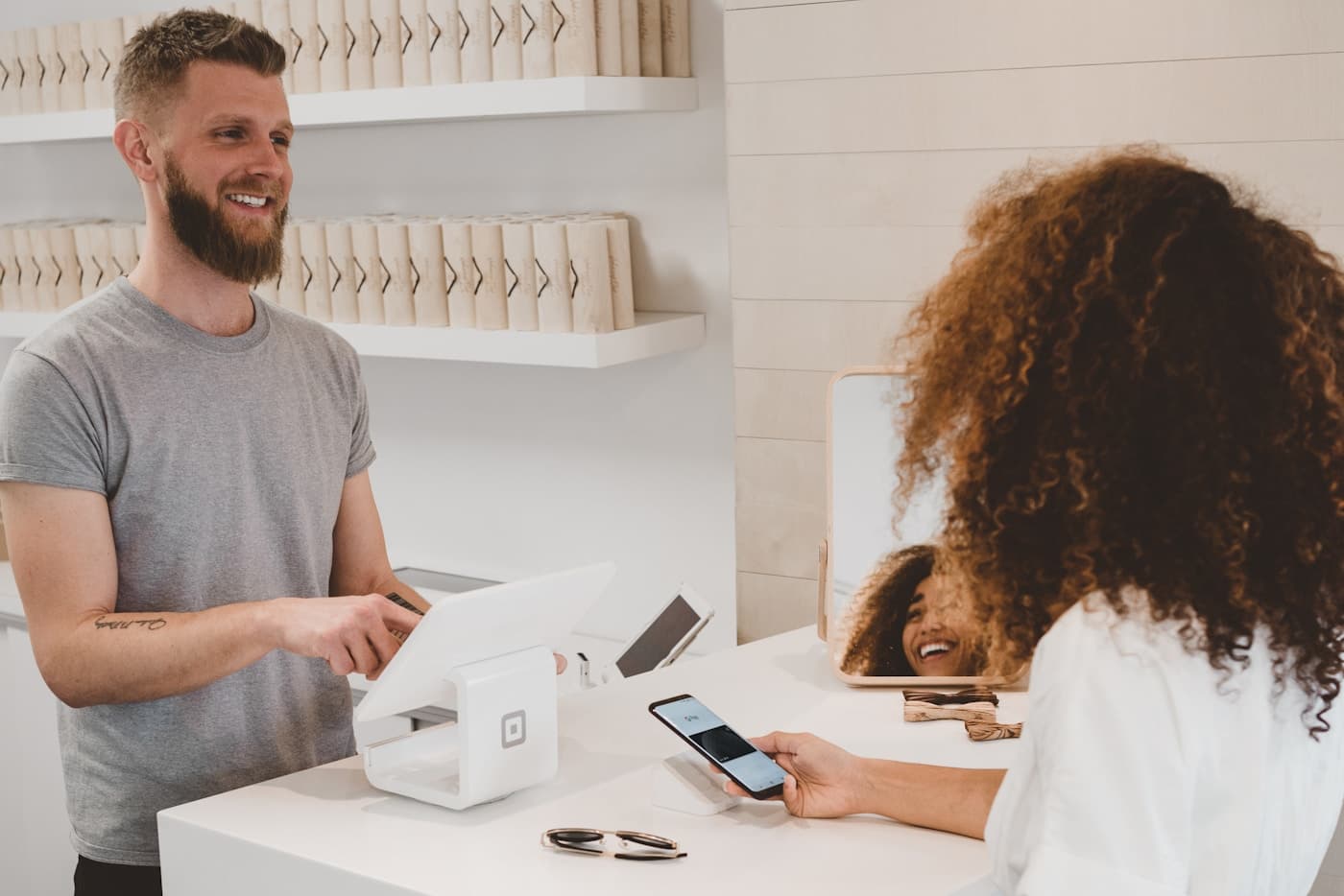 Retail staff using a mobile point-of-sale or logistics handheld device at a counter